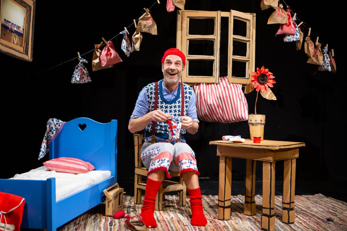 Ein sehr großer Zwerg mit Zipfelmütze sitzt in seiner Wohnstube