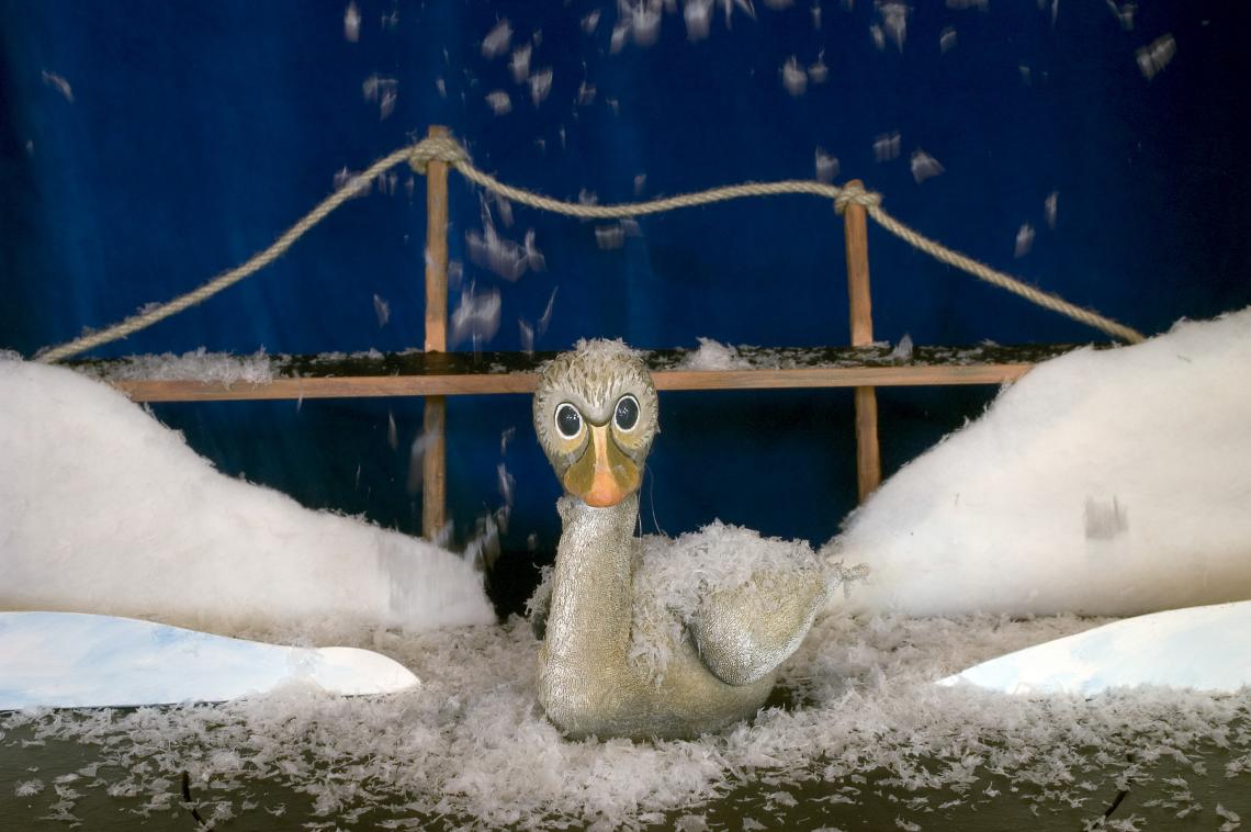 Ein kleiner grauer Vogel sitzt im Schnee.