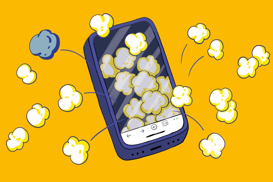 Aus dem Display eines Smartphones springen lauter Popcorn-Körner heraus.