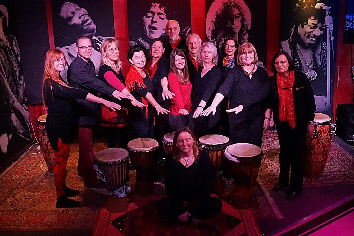 Eine große Percussiongruppe posiert mit ihren Trommeln.