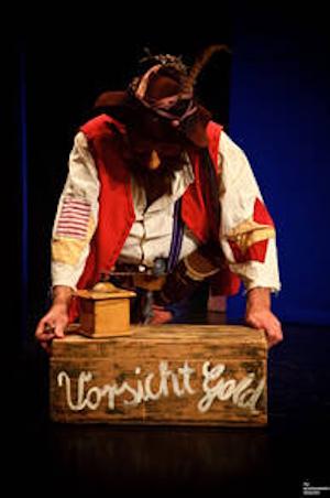 Ein Räuber trägt eine Kiste mit der Aufschrift "Vorsicht Gold"