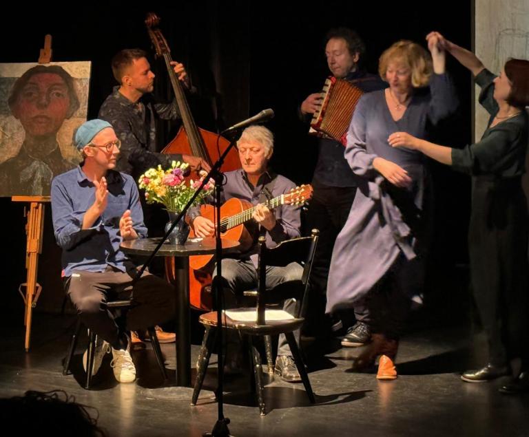 Eine Band spielt und zwei Frauen tanzen dazu - links steht ein Selbstporträt der Malerin Paula Modersohn-Becker