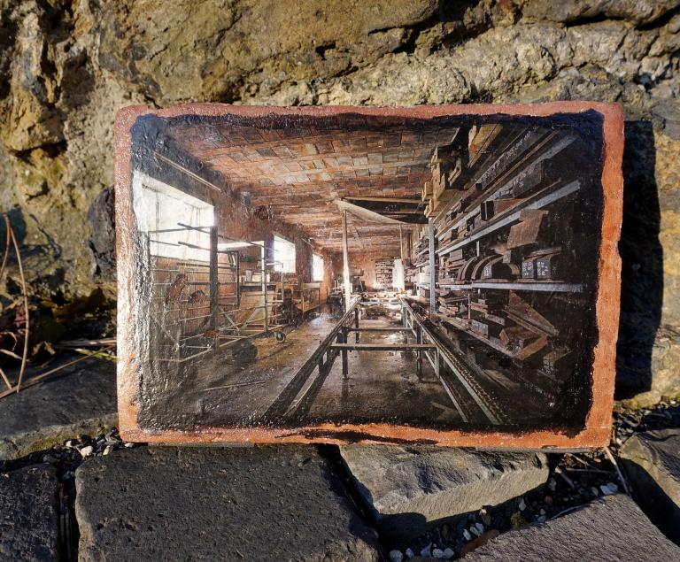 Das Foto einer alten Werkstatt, auf einen Ziegelstein gedruckt.