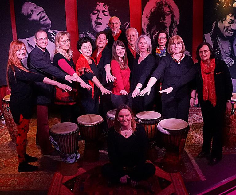 Eine große Percussiongruppe posiert mit ihren Trommeln.